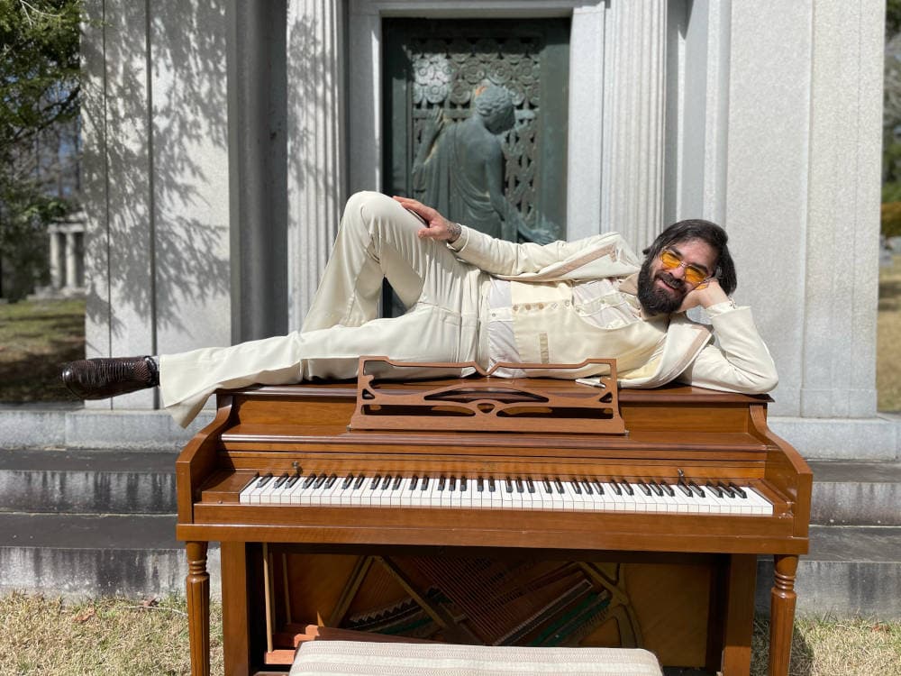Lee laying on a piano